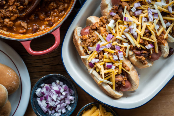 Chili on hot dogs with cheese and onions