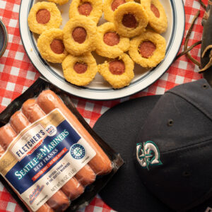 Seatle Mariners branded hot dog package with hand size corn muffins with hot dogs in the middle
